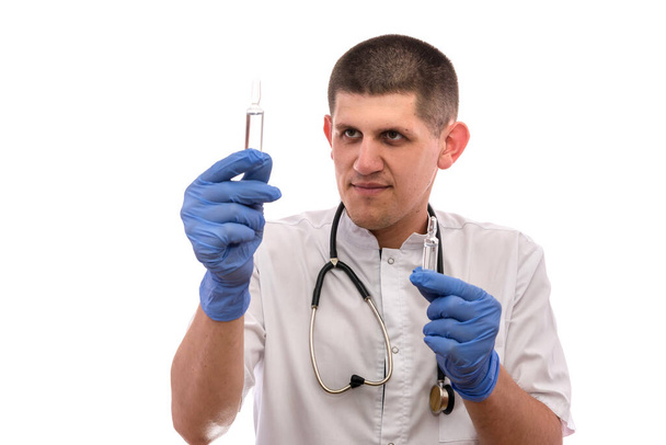 Arzt mit Ampullen. Er trägt Sanitätsuniform und Stethoskop um den Hals - Foto, Bild