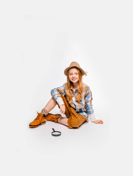 Μακρυμάλλη συναισθηματική κοπέλα με ρούχα ταξιδιώτη κάθεται στο πάτωμα - Φωτογραφία, εικόνα