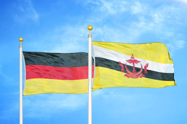 Alemania y Brunei dos banderas sobre asta de bandera y fondo azul cielo nublado
 - Foto, imagen