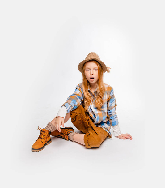 menina emocional de cabelos longos em roupas de viajante senta-se no chão
 - Foto, Imagem