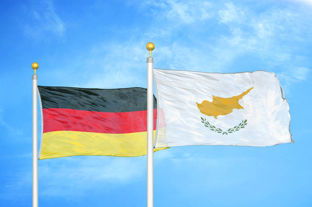 Saksa ja Kypros kaksi lippua lipputangoilla ja sininen pilvinen taivas tausta
 - Valokuva, kuva