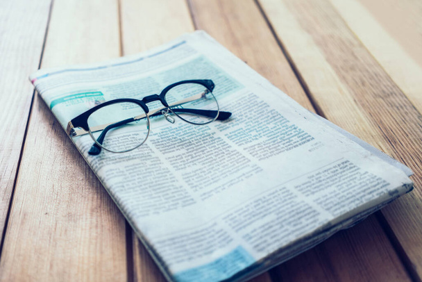 Glasses with Newspaper on wooden table - Foto, Bild
