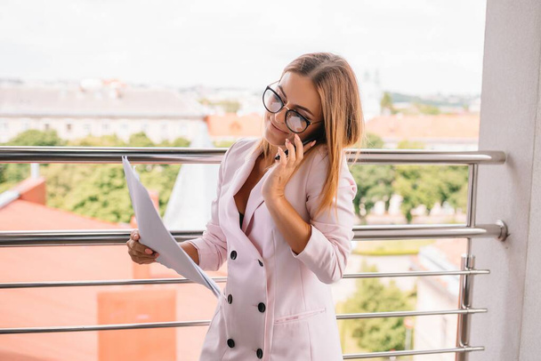 Business woman on the phone at office. Young business woman having phone call at the office. Smiling business woman. Pretty young business using smartphone at the office. - Φωτογραφία, εικόνα