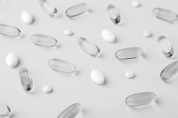 Ассортимент разбросанных фармацевтических препаратов витамины, таблетки, рыбное масло софтгель
 - Фото, изображение