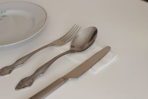 puhtaat ruoanlaittovälineet päivittäiseen käyttöön, tyhjät astiat valkoisella pöydällä taustalla
 - Valokuva, kuva