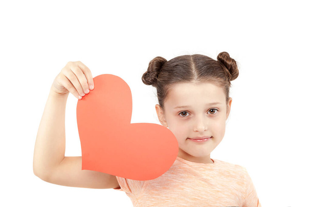 Little bright happy girl with a paper heart in hands isolated on white background. - Photo, Image