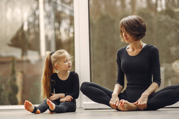 Woman with daughter is engaged in gymnastics - Fotó, kép