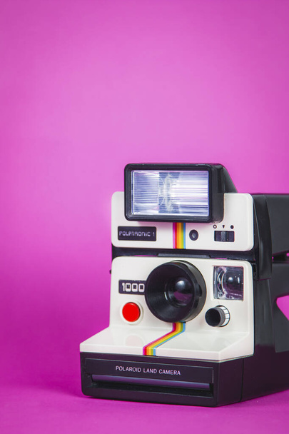 Cámara fotográfica Polaroid sobre fondo rosa vibrante
 - Foto, Imagen
