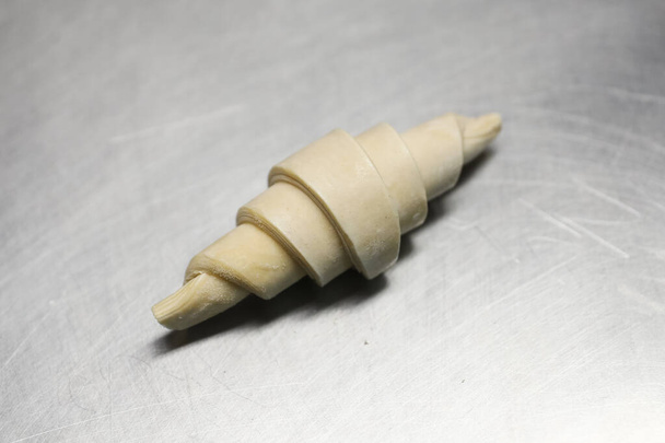 Un croissant congelé sur une plaque de cuisson dans une boulangerie
 - Photo, image