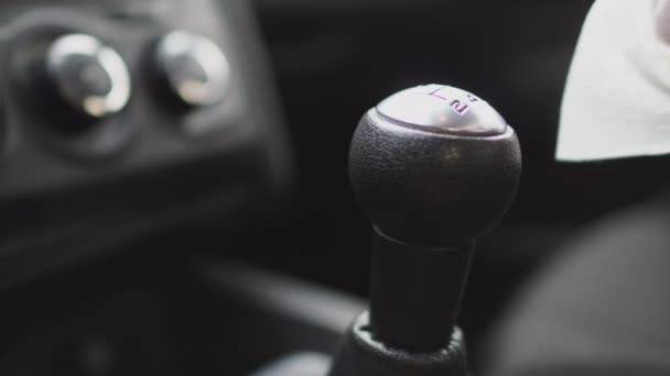 Driver is wiping the gear stick in the car using wet wipe, close up - Séquence, vidéo