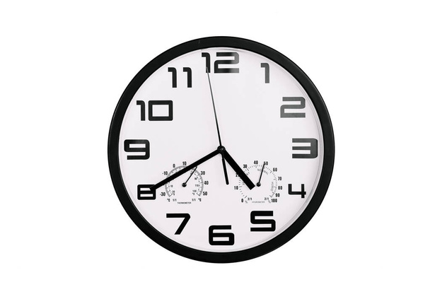 απλό κλασικό μαύρο και άσπρο στρογγυλό ρολόι τοίχου που απομονώνονται σε λευκό. Ρολόι με αραβικούς αριθμούς στον τοίχο δείχνει 16: 40, 4: 40 - Φωτογραφία, εικόνα