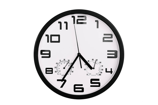simple classic black and white round wall clock isolated on white. Clock with arabic numerals on wall shows 16:35 , 4:35 - Photo, Image