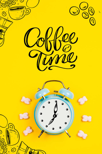 Kék ébresztőóra grafikával és szöveggel Kávéidő sárga alapon - Fotó, kép