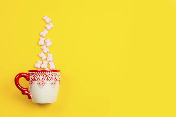 Marmelády, kostky cukru a tyčinky v prázdninovém hrnku na žlutém pozadí - Fotografie, Obrázek