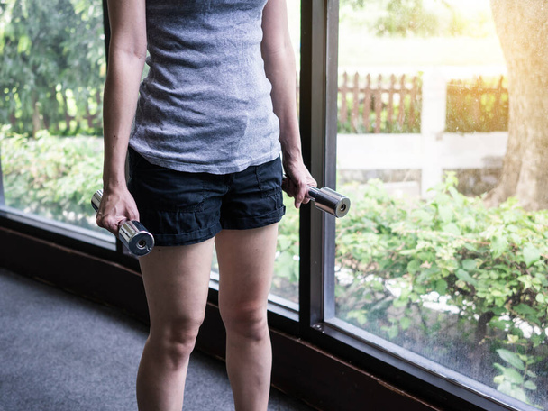 Jeune femme exercice avec haltères dans la salle de gym fitness
 - Photo, image