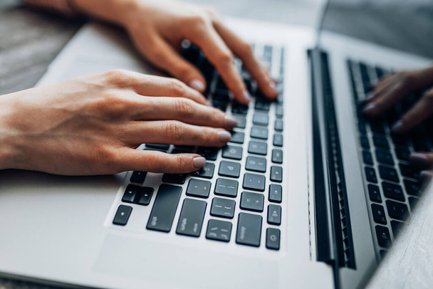 Крупним планом рука ділової жінки, яка використовує і друкує на ноутбуці, на робочому столі
 - Фото, зображення