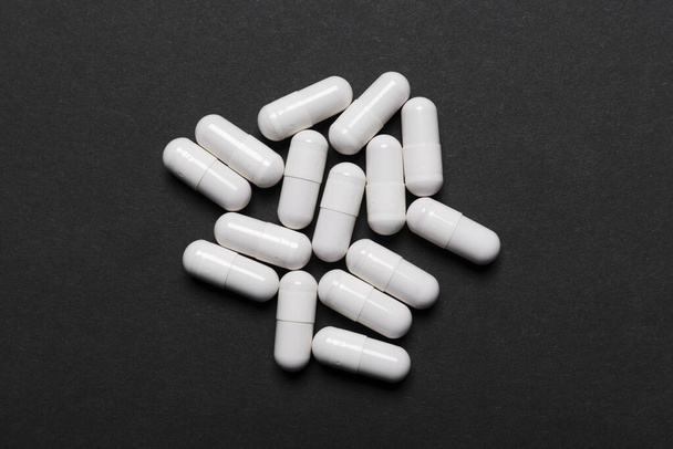 A bunch of white pills on a dark background - Foto, Imagen