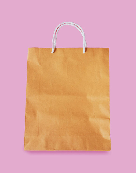 Bolsa de papel marrón aislada sobre fondo rosa con camino de recorte
 - Foto, imagen