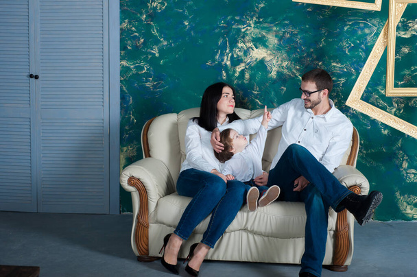 Happy Family Sitting On Sofa In Lounge Talking Together - 写真・画像