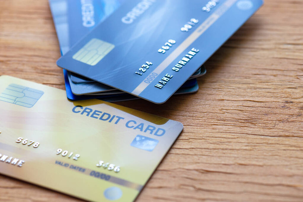 Ułóż karty kredytowe (fałszywe) stos i położyć się na drewnianym stole - Zdjęcie, obraz
