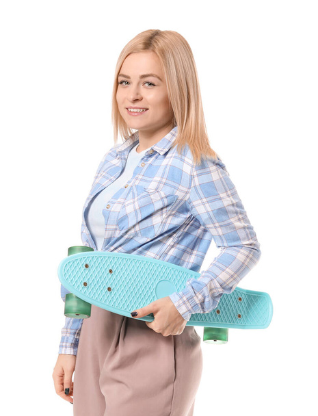 Όμορφη νεαρή γυναίκα με skateboard σε λευκό φόντο - Φωτογραφία, εικόνα