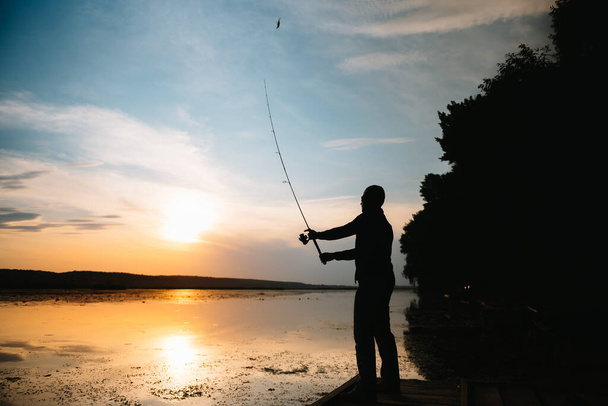Pesca. filatura al tramonto. Silhouette di un pescatore
 - Foto, immagini
