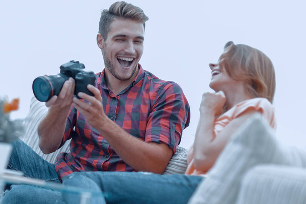 Modernes junges Paar lacht und diskutiert die Fotos in der Kamera - Foto, Bild