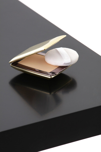 make-up compacte poeder op zwarte tabel geïsoleerd op een witte pagina - Foto, afbeelding