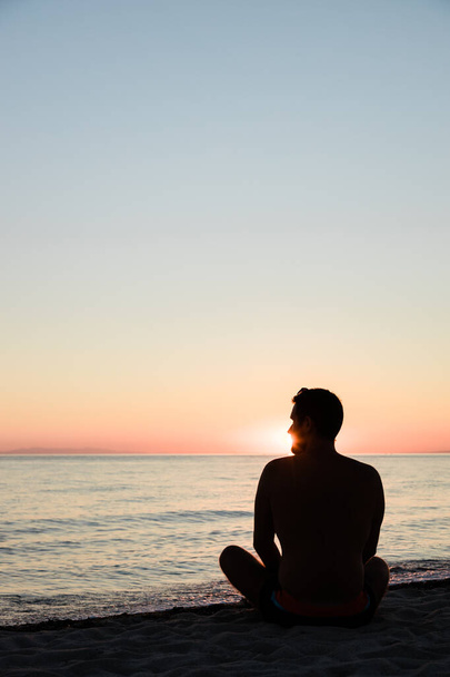 Giovane uomo godendo il tramonto sulla spiaggia
 - Foto, immagini