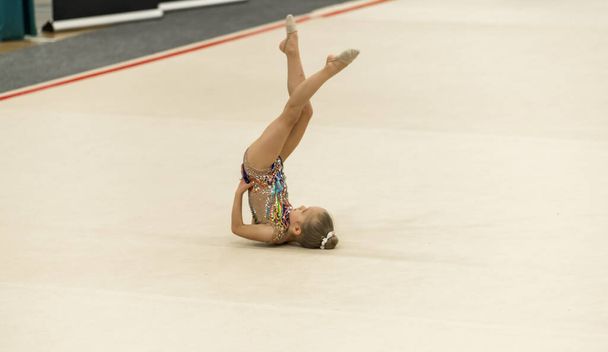 Portrait of a young gymnast. Portrait of a 7 years old girl in rhythmic gymnastics competitions - Photo, Image