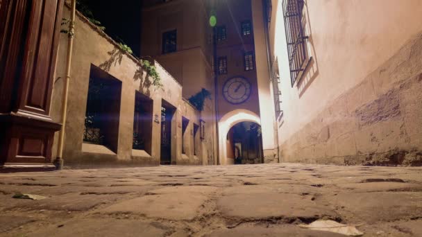 Time laps night street night walking tourists Clock over the arch of the house going in the opposite direction Lviv Ukraine 2019 - Footage, Video