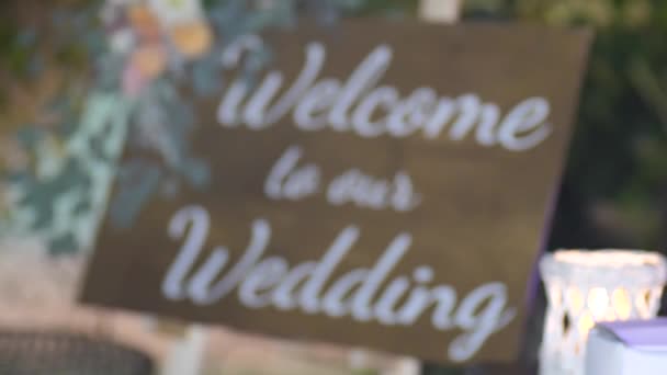 Welcom to our beginning. Maridge, frame.welcome sign on it decorated with flowers outdoor. - Footage, Video