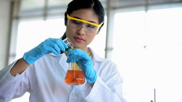 asiatico femmina scienziato in uniforme holding test Tubo in laboratorio
 - Foto, immagini