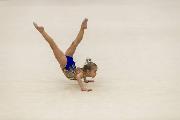 Nuoren voimistelijan muotokuva. 7-vuotiaan tytön muotokuva rytmisissä voimistelukilpailuissa
 - Valokuva, kuva