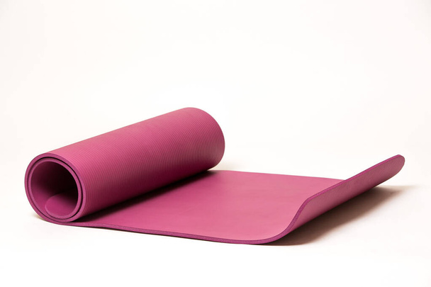 Esterilla de yoga rosa sobre fondo blanco, aislado, espacio para copiar
 - Foto, Imagen