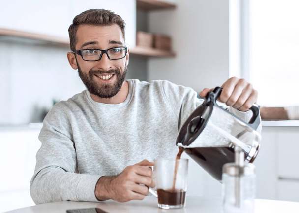 attractive man pouring himself a Cup of morning coffee - Foto, Imagen