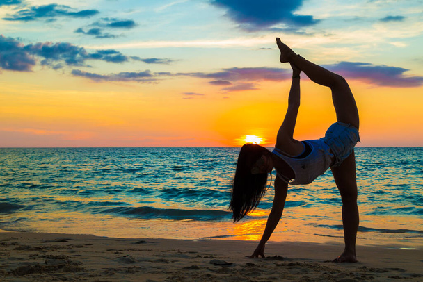 Young healthy women practicing yoga at sunset on beach, Healthy lifestyle concept - Foto, Imagem