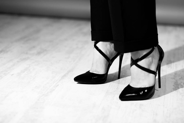 Vrouw benen in zwart lakleer hoge hak schoenen, fashoin en stijlvol, close-up, zwart en wit - Foto, afbeelding