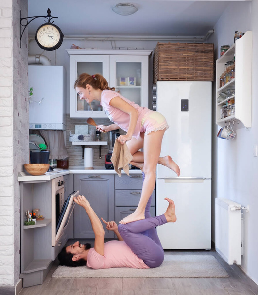 Giovane coppia divertirsi a casa con alcune pose acro yoga in luoghi diversi
. - Foto, immagini