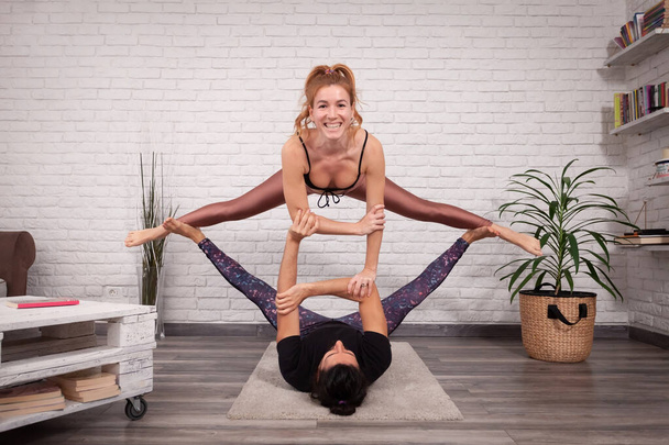 Jeune couple s'amusant à la maison avec quelques poses d'acro yoga dans différents endroits
. - Photo, image