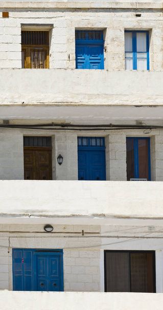 Malta 'da pencere, kapı ve balkonları yapıcılık tarzında olan basit bir bina - Fotoğraf, Görsel