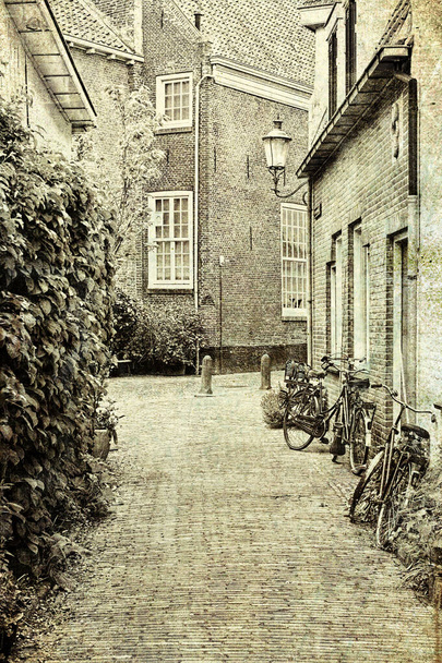 Typische holländische Backsteinhäuser in Holland. Street View mit Fahrrädern, die im historischen Zentrum von Amersfoort in den Niederlanden geparkt sind. Vintage-Stil getöntes Bild - Foto, Bild