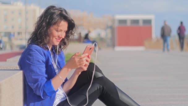 Happy smiling young woman listening to music using mobile. - Filmagem, Vídeo