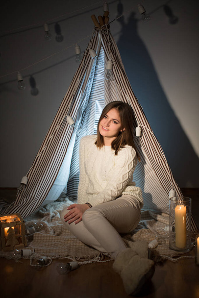 Beautiful girl on Christmas eve, sitting in a comfortable interior. New year - Fotoğraf, Görsel