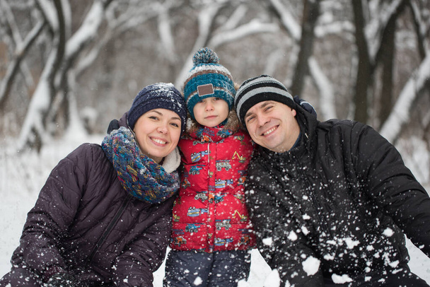 Portrait of happy family in warm clothing in winter outdoors. - Photo, Image