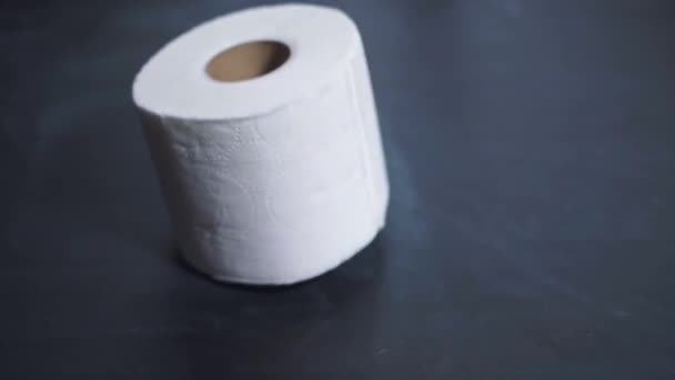 A roll of toilet paper slowly falls onto the table. Toilet paper shortages during a crisis and pandemic. The financial crisis 2020 - Video