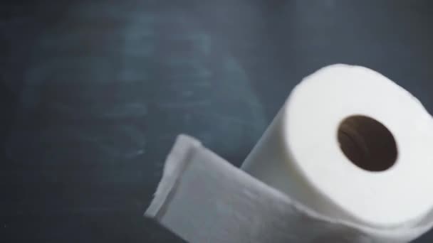 A roll of toilet paper slowly falls onto the table. Toilet paper shortages during a crisis and pandemic. The financial crisis 2020 - Video