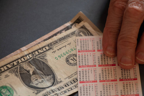 vanha nainen käsi ja kalenteri dollareita pöydällä, laskenta kotiin budjetti
 - Valokuva, kuva