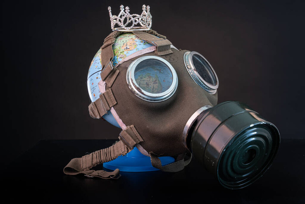 μάσκα αερίου σε μια υδρόγειο για την προστασία από τον ιό της στέψης - Φωτογραφία, εικόνα