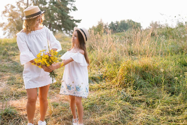 Mother and daughter having fun in the park. Happiness and harmony in family life. Beauty nature scene with family outdoor lifestyle. - Foto, imagen